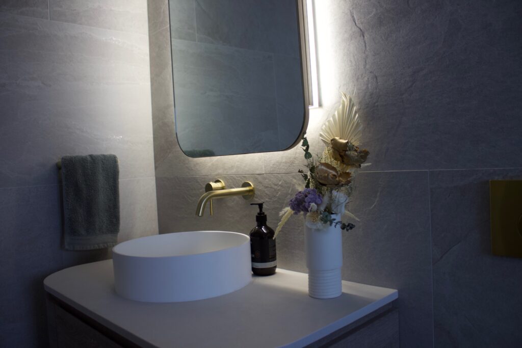 photo of backlit mirror with white tile splashback